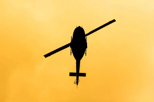 Helicopter flying in the orange sky — Stock Photo, Image