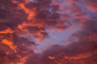 Parlak turuncu güneş mor bulutun arka planında yükselir