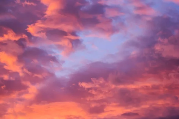 明亮的橙色太阳在紫色云的背景下升起 — 图库照片