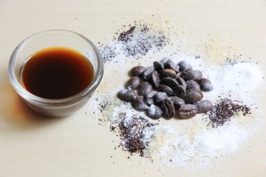 Kahve çekirdeği, şeker ve krema, ahşap arka planda.