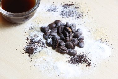 Kahve çekirdeği, şeker ve krema, ahşap arka planda.