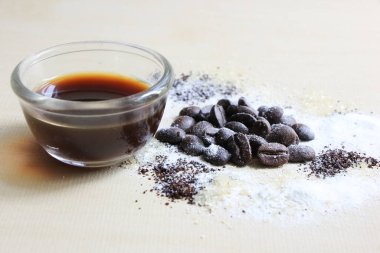 Kahve çekirdeği, şeker ve krema, ahşap arka planda.