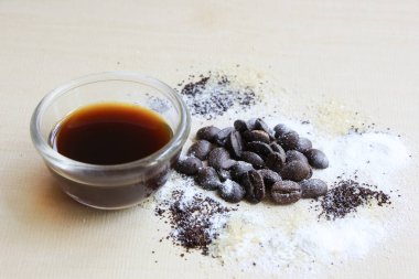 Kahve çekirdeği, şeker ve krema, ahşap arka planda.