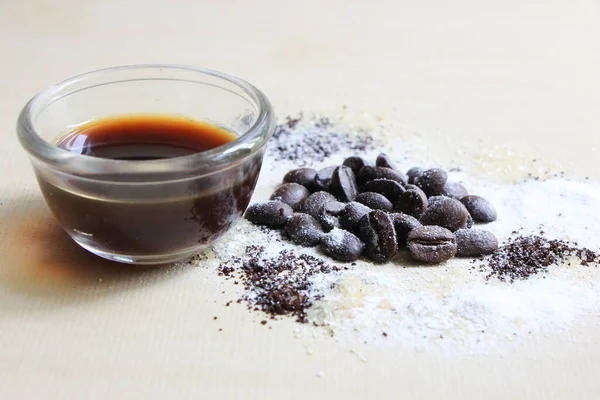 Kahve çekirdeği, şeker ve krema, ahşap arka planda.