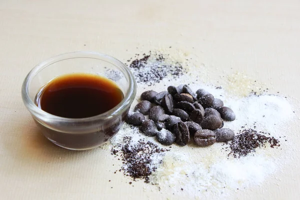 Kahve çekirdeği, şeker ve krema, ahşap arka planda.