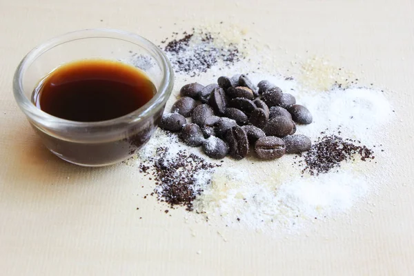 Kahve çekirdeği, şeker ve krema, ahşap arka planda.