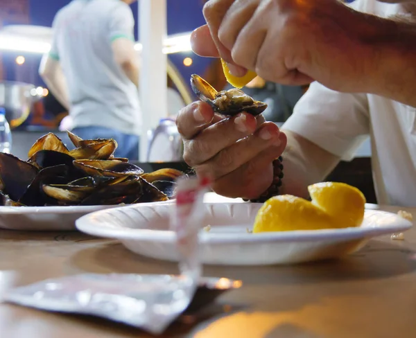 stuffed mussels and man squeeze lemon. midye dolma in Turkish language