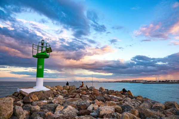 Renkli bir günbatımında Saplaya Limanı 'nın girişindeki deniz feneri manzarası. Valencia