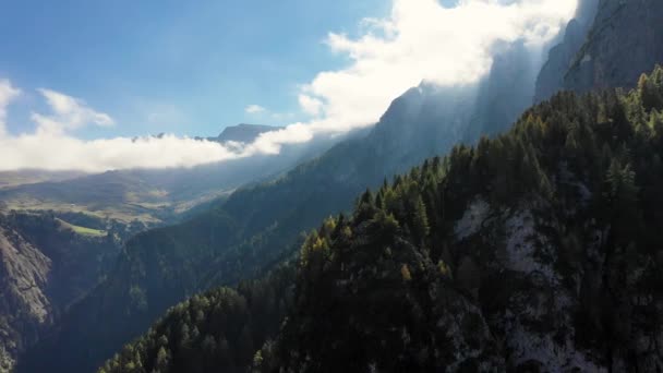 Ein Blick aus der Höhe eines Vogelfluges nach Sonnenaufgang auf die hohen Gipfel eines Berges zwischen den Wolken. Bozen in den Dolomiten. Italien im Herbst — Stockvideo