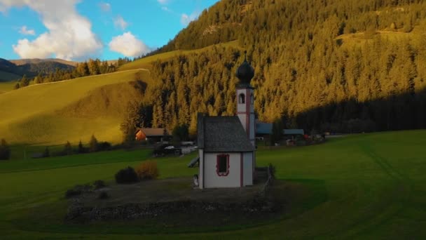 Lotu ptaka widok Kościoła i dolinie w pobliżu miejscowości Santa Maddalena. W tle są szczyty Dolomitów. Jesień, Włochy — Wideo stockowe