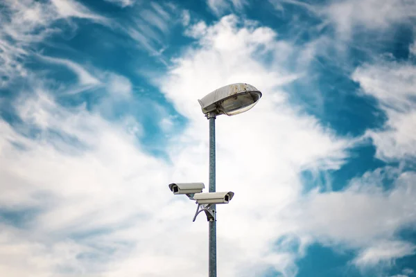 Cámara de seguridad CCTV se instala en dos direcciones en el poste en el fondo del cielo —  Fotos de Stock