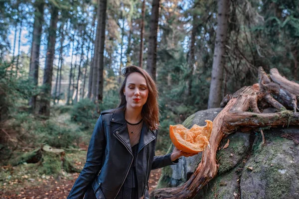 Fiatal gyönyörű nő bőrkabát erdőben sütőtökkel — Stock Fotó