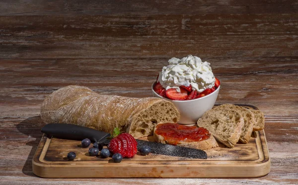 Tabla con rebanadas de pan y deliciosa mermelada de fresa en mesa de madera — Foto de Stock
