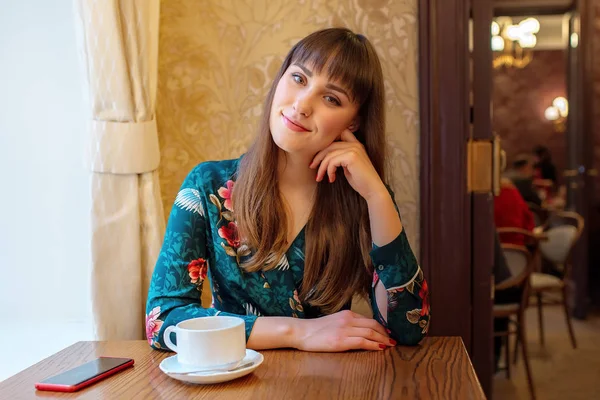 Hermosa joven con una taza de té en un café Imágenes De Stock Sin Royalties Gratis