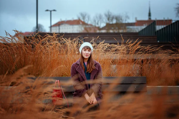 Mujer sentada en el banco observando hojas amarillas en otoño . — Foto de Stock