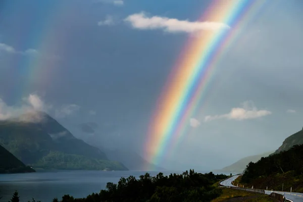 Gökkuşağı. Gökkuşağının üstünde bir fiyort Norveç'te. Norveç dili. Yağmur.