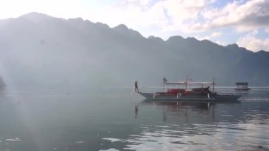 Filipinler. Güneşin doğuşunda balıkçı teknesi.