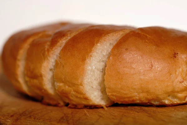 Pão Fresco Cortado Pedaços Uma Tábua Madeira Closeup Profundidade Campo — Fotografia de Stock