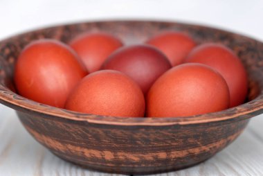 Açık bir arka plan önünde seramik bir tabakta Paskalya yumurtaları. S