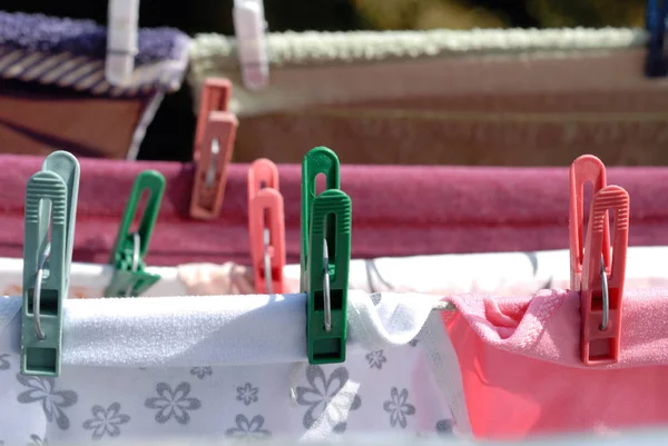 Giysiler iplere asılmış mandallarla kurumuş.