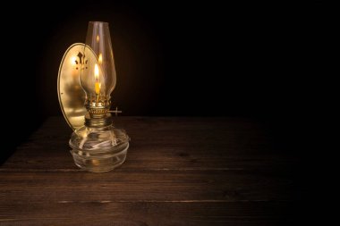 Masanın üzerine karanlıkta eski yağ lambası ışık yanan