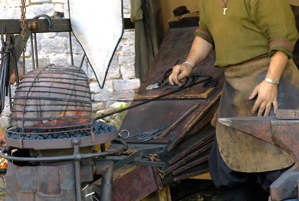 铁匠在中世纪的铁匠吹煤用手锻造波纹管 — 图库照片