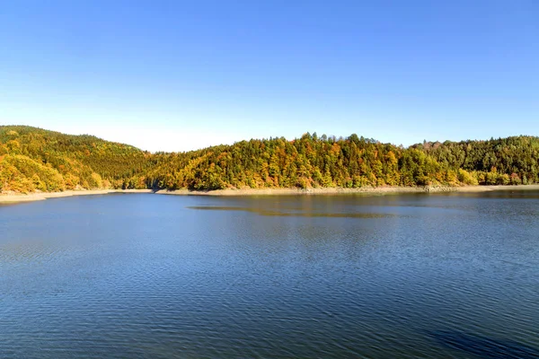 Foresta autunnale sulle acque blu del lago — Foto Stock