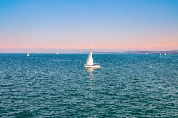 Gün batımında uzak sahillerin arka planında yatlar