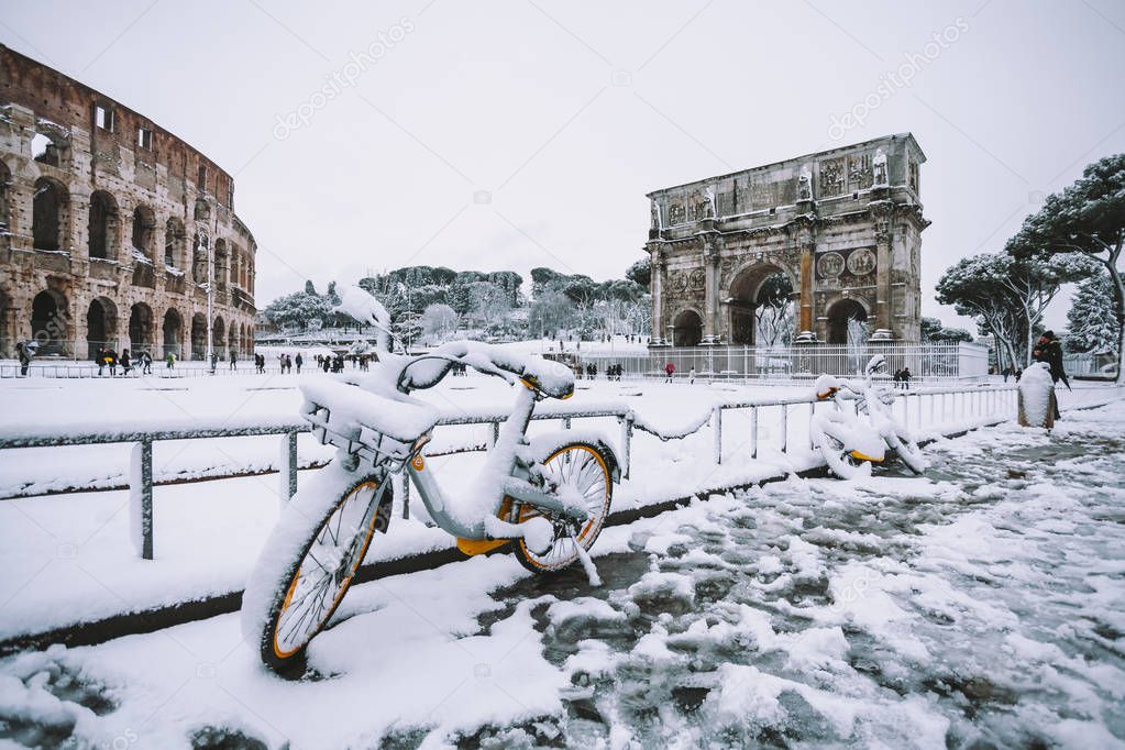 A lovely day of snow in Rome, Italy, 26th February 2018: a view of snowy bikes behind the Colosseum