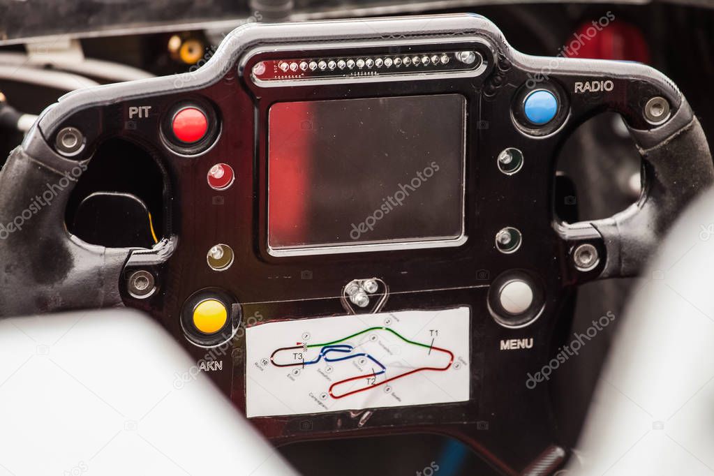 Closeup view of inside of a supercar. Steering wheel controls