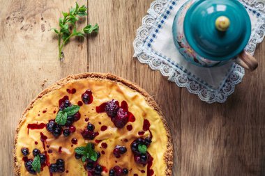 Kırmızı meyve, nane ve ahşap arka plan üzerinde pudra şekeri ile güzel geleneksel İtalyan cheesecake