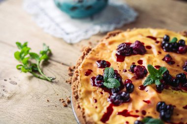 Kırmızı meyve, nane ve ahşap arka plan üzerinde pudra şekeri ile güzel geleneksel İtalyan cheesecake