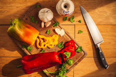 Etraflarında bazı malzemeler ile doğrama tahtası üzerinde iki biber bir görünüm: sarımsak, maydanoz, yağ