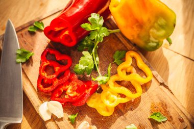 Etraflarında bazı malzemeler ile doğrama tahtası üzerinde iki biber bir görünüm: sarımsak, maydanoz, yağ