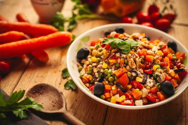 Blick auf ein Dinkelgericht auf hölzernem Hintergrund mit einigen Zutaten rundherum: Möhren, Paprika, Tomaten, Petersilie und Öl — Stockfoto