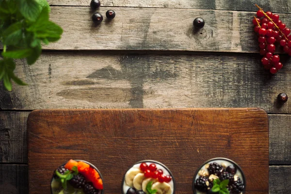 Proteic greek yogurts with fruits: banana, berries, kiwi Stock Image
