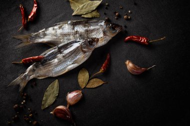 Siyah bir arka plan üzerinde baharat ile kurutulmuş balık natürmort