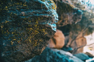 Biraz daha odaklanmamış taş arka plandaki ve moss ile büyük bir taş eğik