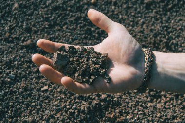 Volkanik kayalara tutan bir insan eli Close-up