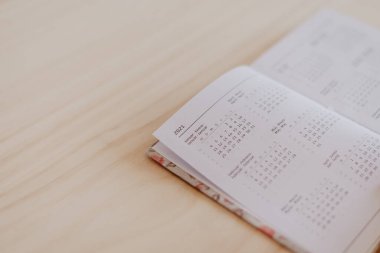 2021 takviminde açık bir planlayıcı, ahşap bir masanın üstünde.