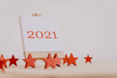 2021 'de, dekoratif ahşap yıldızlı bir resim sehpasında kırmızıyla yazılmış..