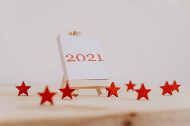 2021 'de, dekoratif ahşap yıldızlı bir resim sehpasında kırmızıyla yazılmış..