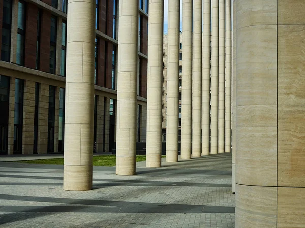 Perspective view of stone pillars and pavement of modern walking gallery of building exterior