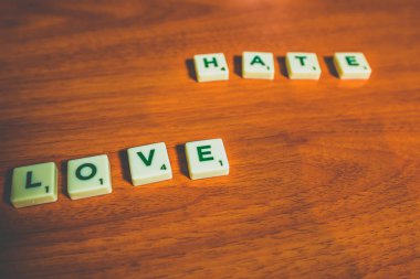 Aşk ve nefret ile dile adet ahşap bir masaya scrabble