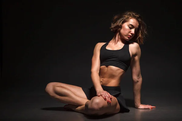 Young girl doing yoga on a black background — Stock Photo, Image