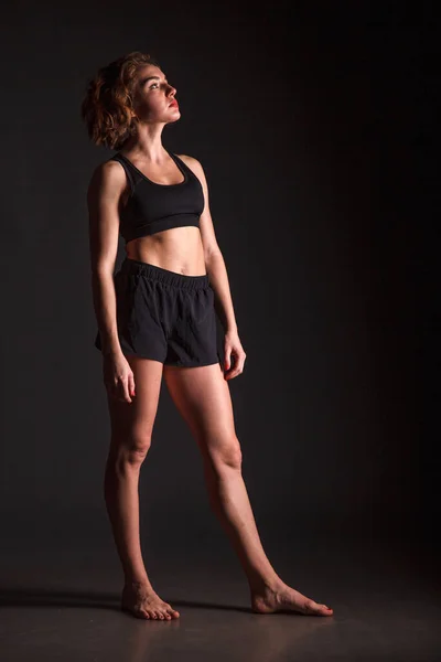 Young girl doing yoga on a black background — Stock Photo, Image