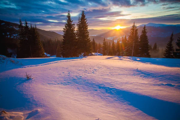 在美丽的白雪覆盖的群山中，太阳从山后升起 — 图库照片