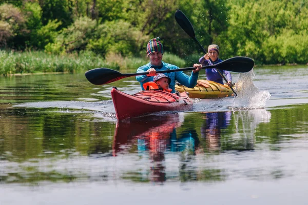 Unga familje flottar på en lugn vacker flod på två kajaker — Stockfoto