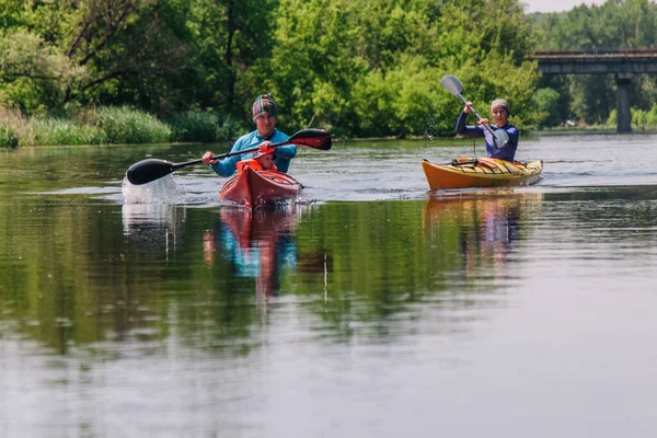 Jeunes radeaux familiaux sur une belle rivière tranquille sur deux kayaks — Photo