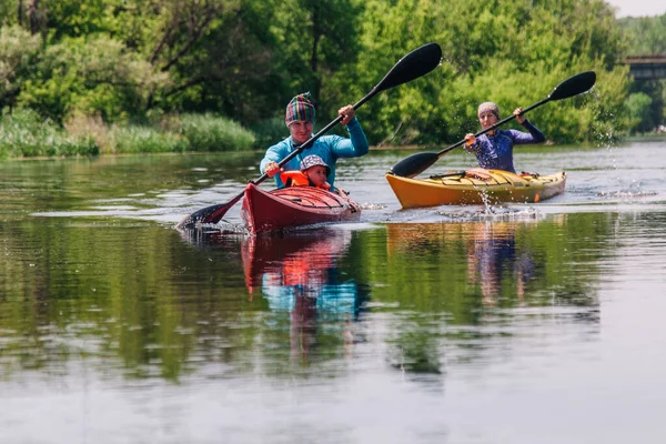 Giovani zattere di famiglia su un bellissimo fiume tranquillo su due kayak — Foto Stock